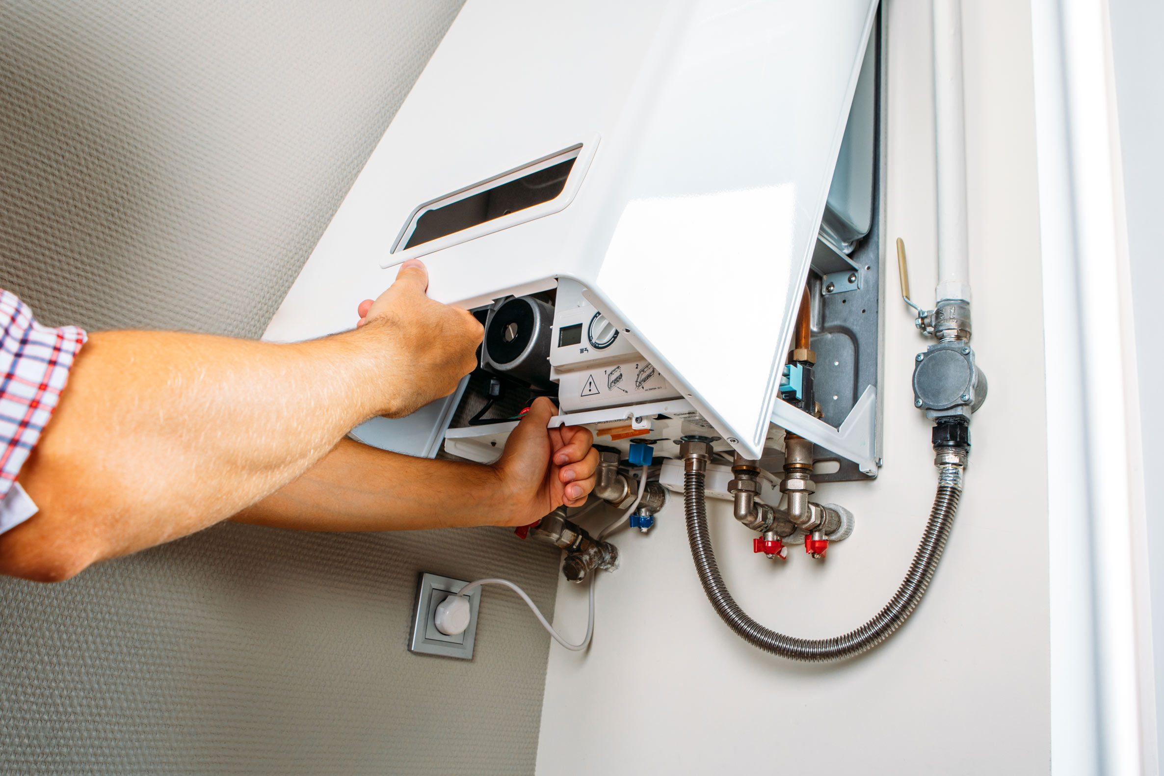 Installateur tauscht eine alte Gastherme in einer Wiener Wohnung